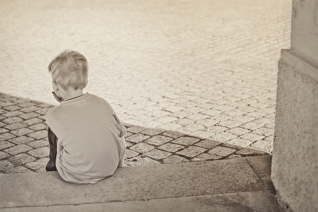 boy sitting on a step looking sad